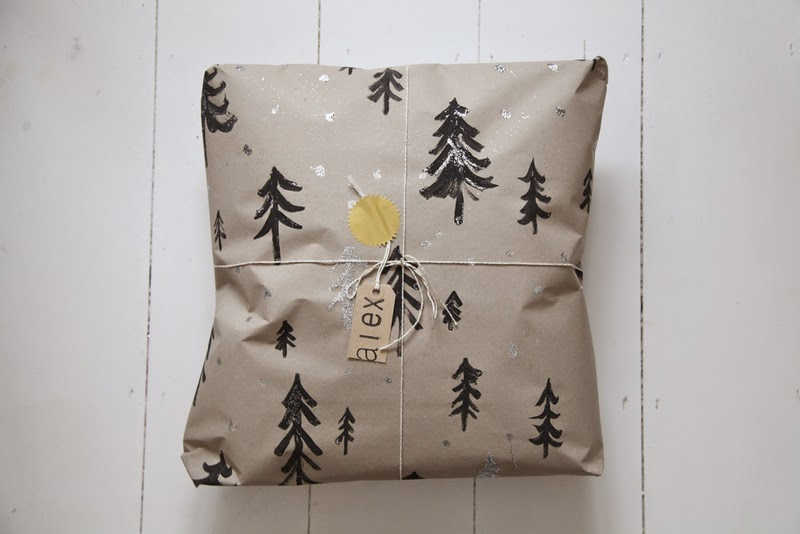 Image showing a Christmas gift wrapped in eco-friendly wrapping paper that has been upcycled using packaging paper, and painted with Christmas trees.