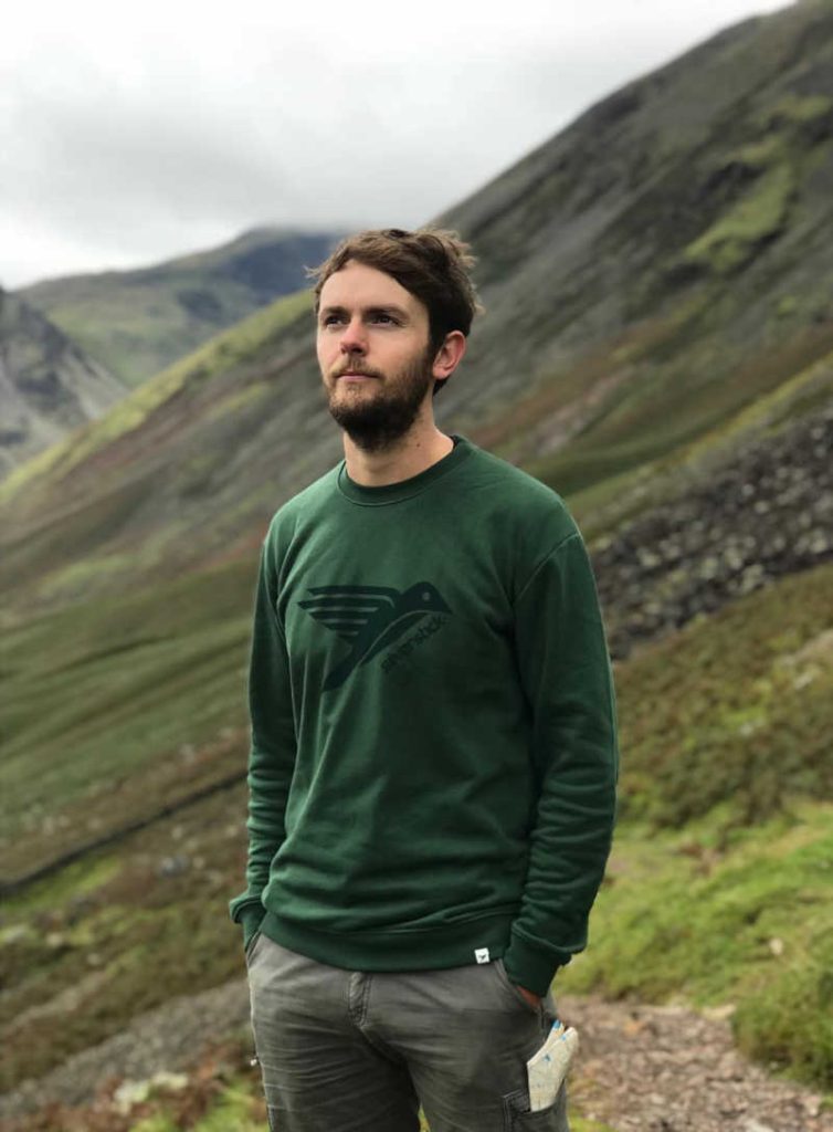 Person wearing a green Silverstick jumper, just one of the affordable sustainable and ethical clothing brands featured.
