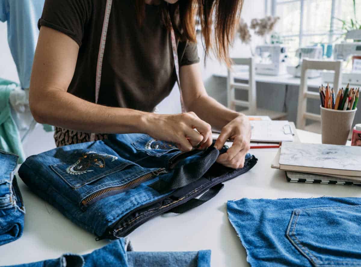 Person upcycling a pair of jeans.