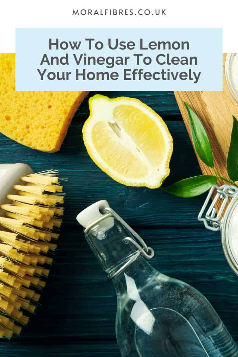 Bottle of white vinegar and a cut lemon on a dark blue surface, with a blue text box that reads how to use lemon and vinegar to clean your home effectively.