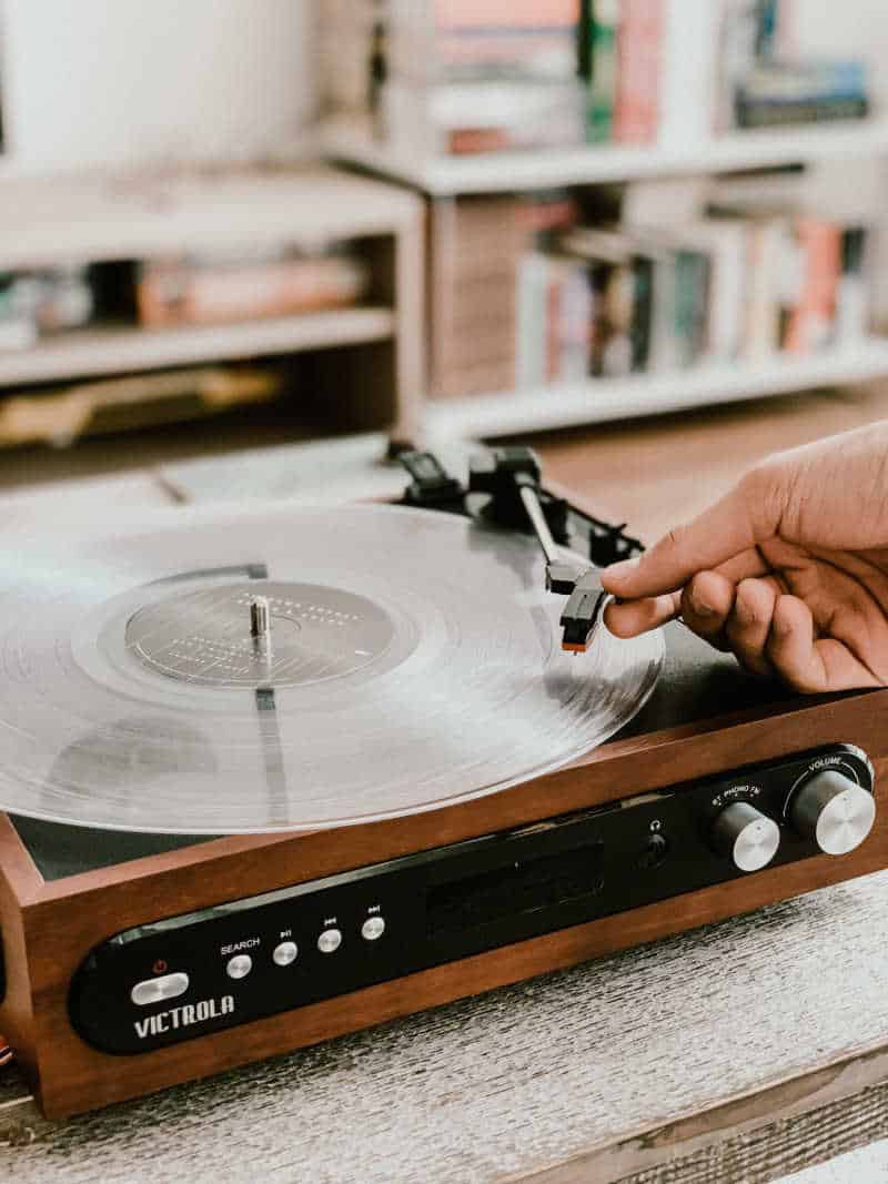 Person playing vinyl on a vintage record player.