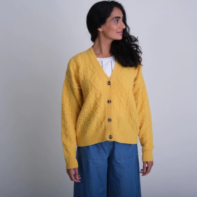 Person wearing a yellow knitted cardigan from sustainable fashion brand Bibico.
