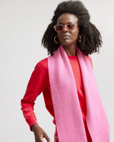 Person wearing a red top and pink scarf from women's ethical clothing brand Colorful Standard.