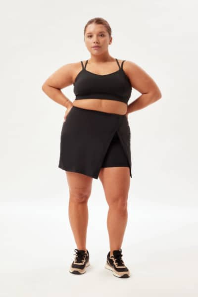 Person wearing Girlfriend Collective recycled shorts in black.