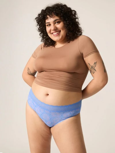 Curly-haired person wearing Modibodi knickers in blue.