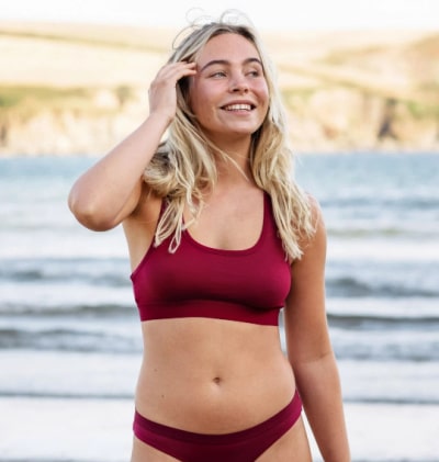 Person wearing Rapanui's sustainable bra and knickers in burgundy.