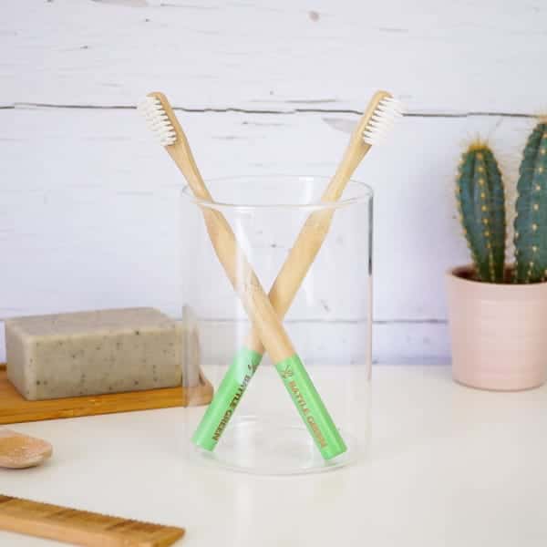 Battle Green plastic-free toothbrushes in a glass jar.