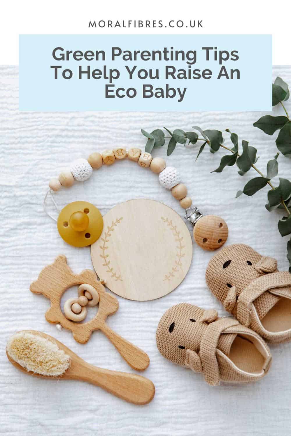 Sustainable wooden toys on a white muslin cloth with a blue text box that reads green parenting tips to help you raise an eco baby.