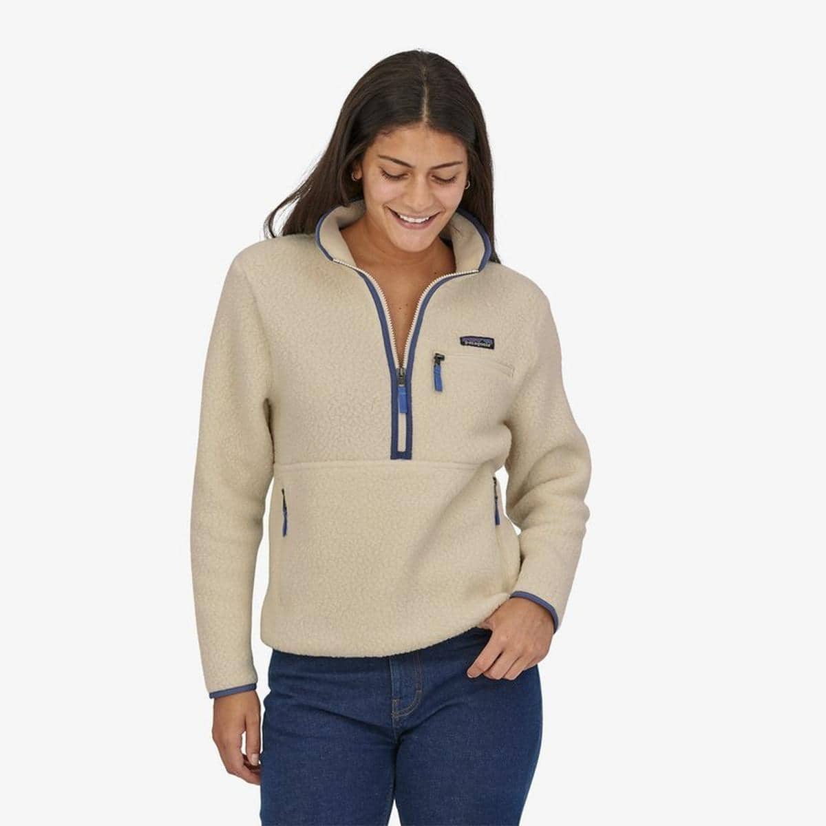 Person wearing a cream fleece and jeans from outdoor brand Patagonia