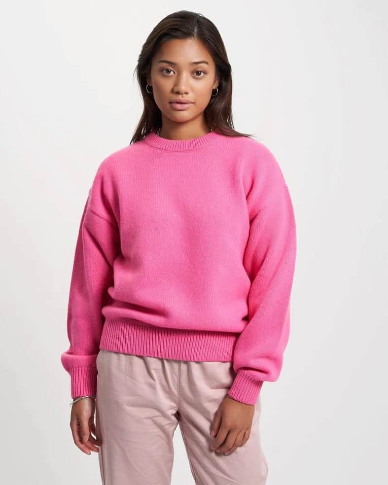 Person wearing pink recycled merino knitwear from Colorful Standard.