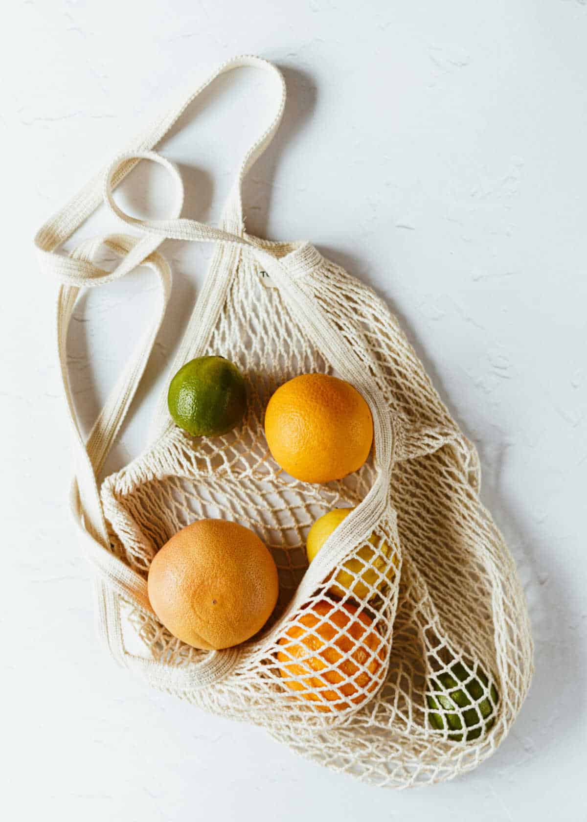 String shopping bag filled with citrus fruits