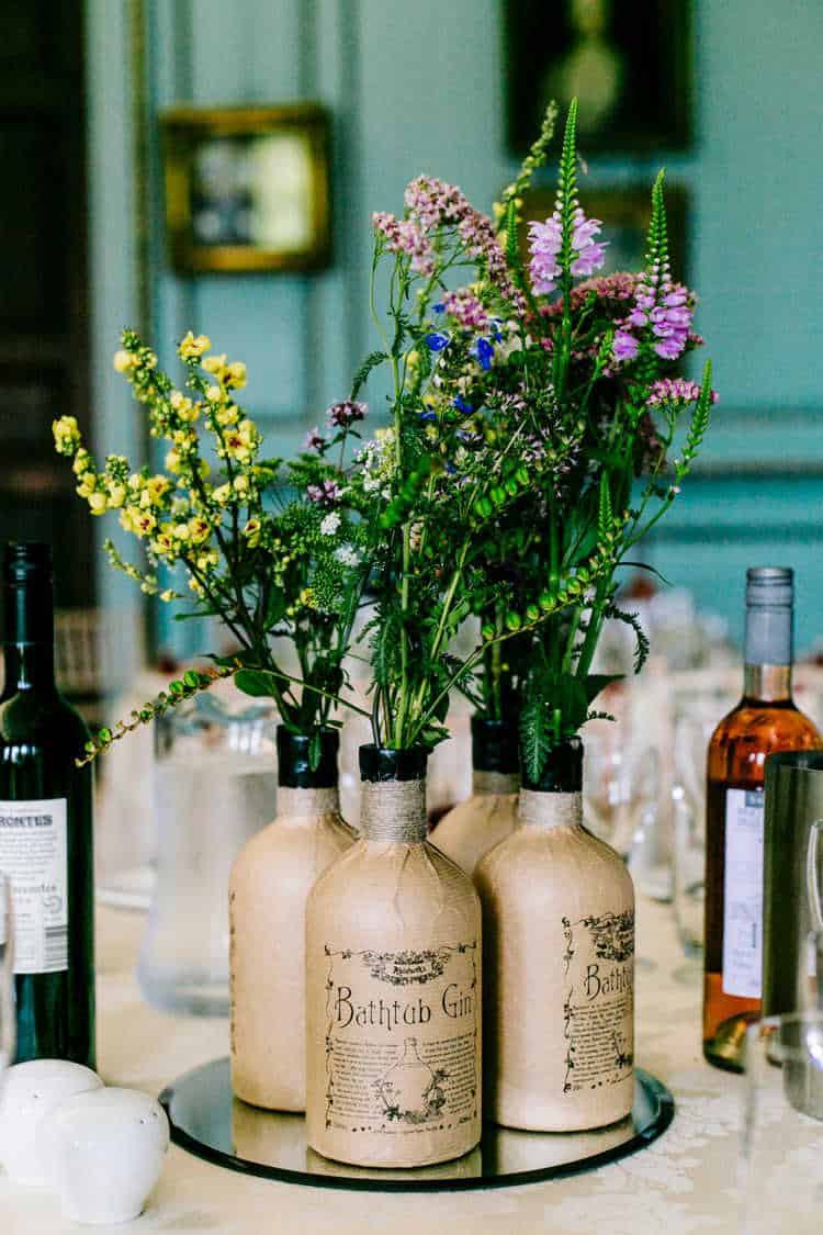 Brown Bathtub gin bottles reused as vases on a wedding table.